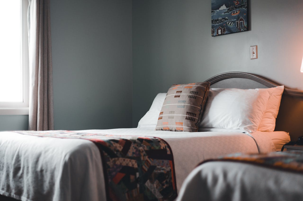 Inviting hotel room interior with a neatly arranged bed and soft lighting.